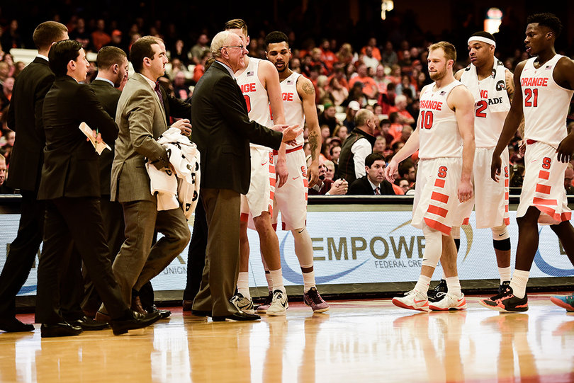 Head coach Jim Boeheim greets his players at the bench as they come off the floor.