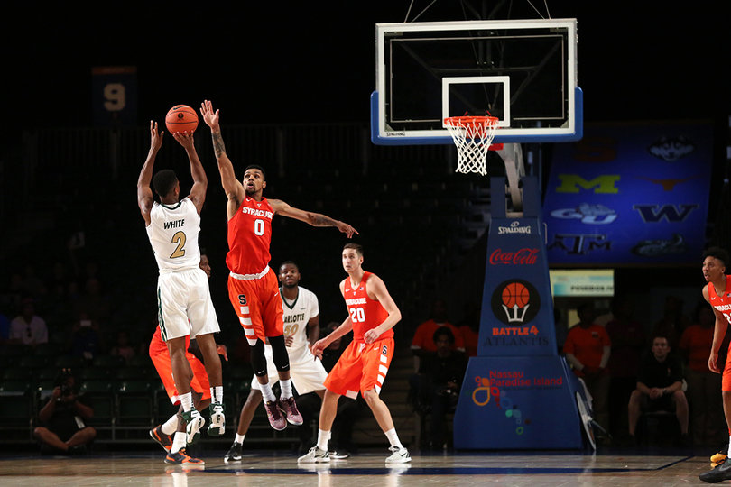 Charlotte's Andrien White of shoots the ball with Michael Gbinije defending him.