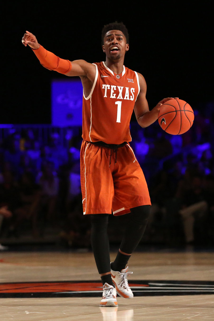 Isaiah Taylor brings the ball up court while pointing out directions to teammates.