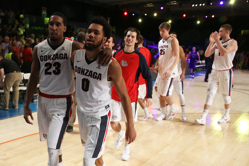 Eric McClellan (23) puts his arm around Melson as they walk off the court. 