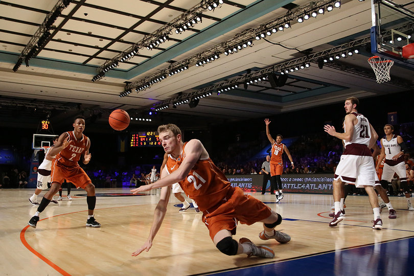 The Longhorns' Connor Lammert falls to the hardwood as the ball is redirected to Demarcus Holland.