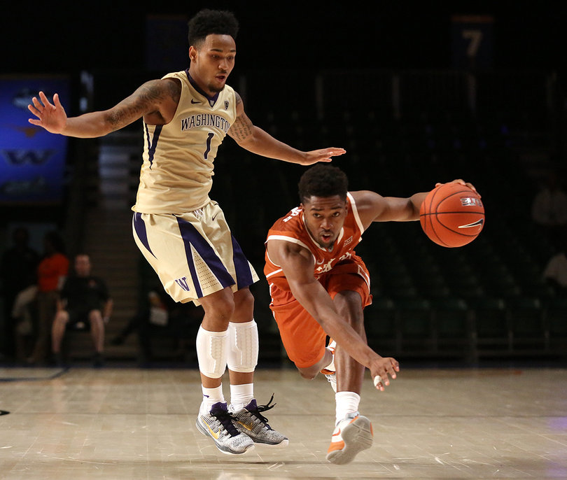 Longhorns guard Isaiah Taylor dribbles past Washington guard David Crisp (1). Taylor chipped in 14 points in the win.  