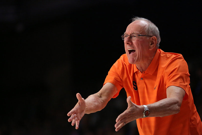 Syracuse head coach Jim Boeheim yells toward the court while extending his arms.