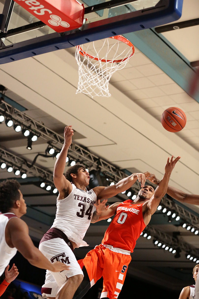 Gbinije is covered by Tyler Davis as he approaches the rim.