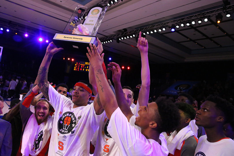 Coleman lifts the trophy above his head. The Orange beat two ranked teams in as many days.
