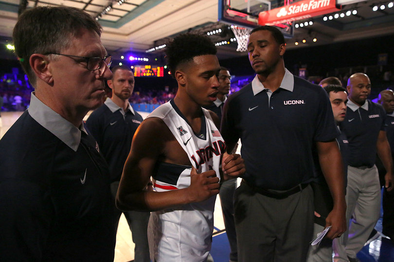 A UConn player walks off the court after the No. 18 Huskies were upset by Syracuse. The Orange had just two top-25 wins last year. 