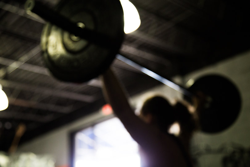 Lilly Thomann, from New Jersey, does a Power Snatch to warm up before the women's weightlifting meet.