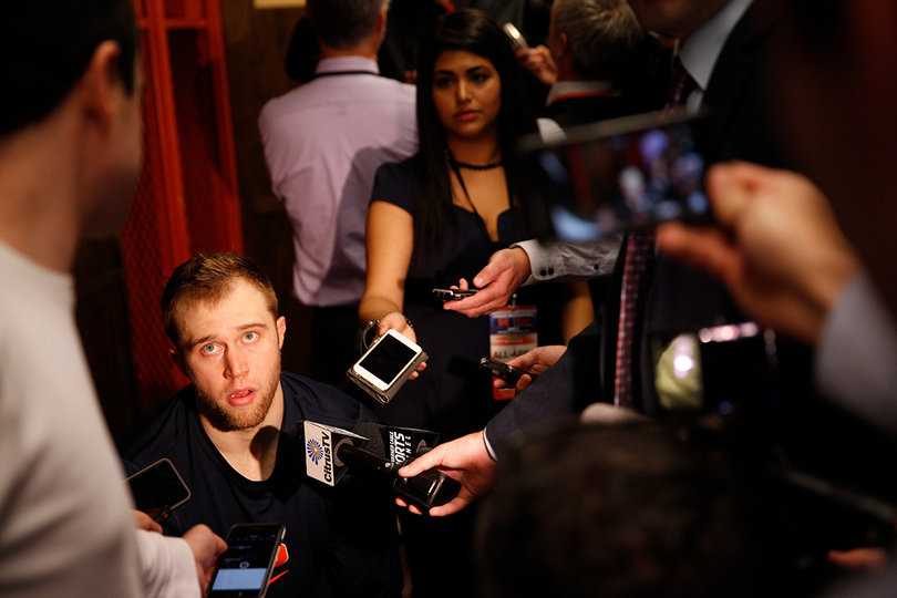 Cooney sits between reporters after SU's 66-58 loss to Wisconsin. 