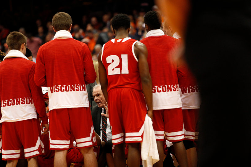 Wisconsin coach Bo Ryan sits in the huddle with his team surrounding him. 