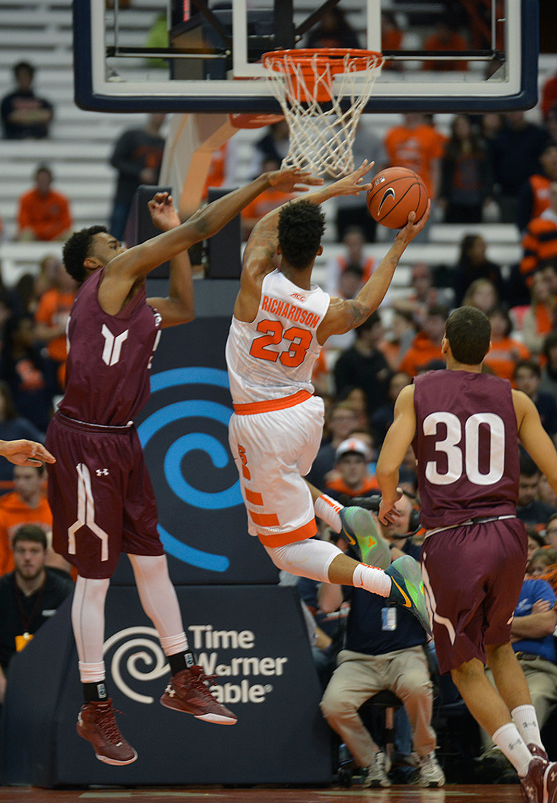 Richardson attacks the rim as Colgate's Francisco Amiel (30) looks on.