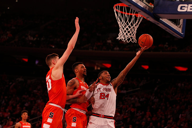 Ron Mvouika drives past Lydon and Gbinije and attempts to put the ball into the hoop.