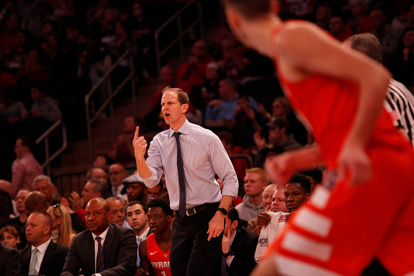 Hopkins calls out to his players while holding one finger in the air.