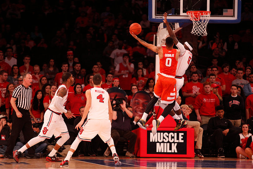 Michael Gbinije puts up a lefty layup while absorbing contact near the basket.