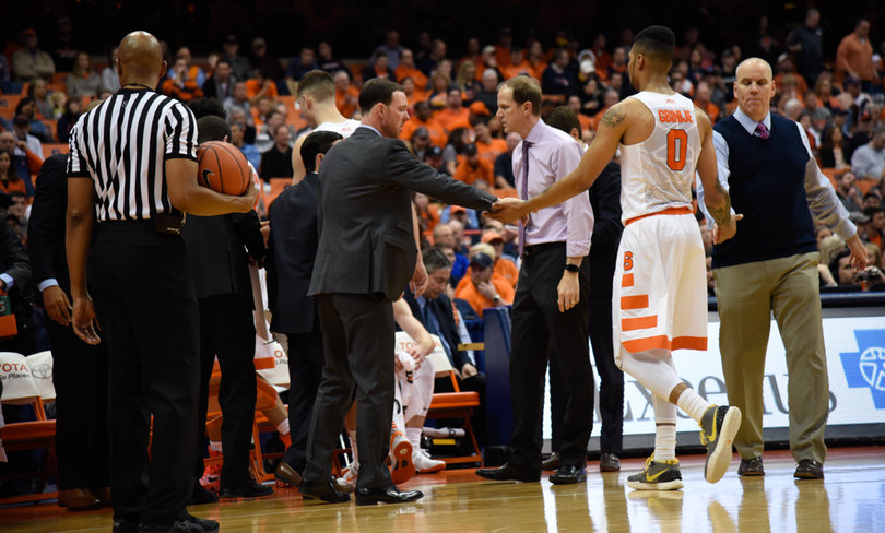 Gbinije walks toward the SU sideline while receiving high-fives from members of the Orange's staff.