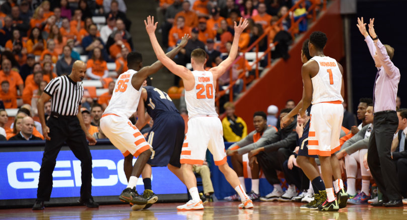 Lydon and Obokoh extend their arms up as they trap a Bobcats player near the Syracuse sideline.