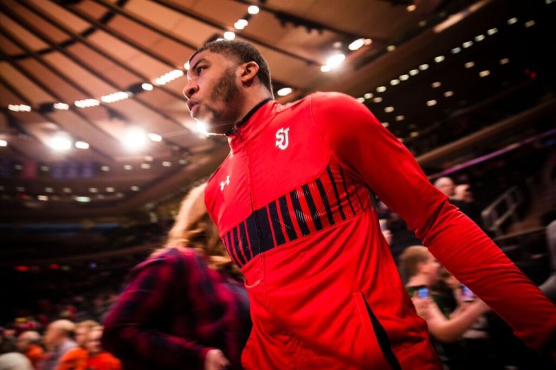 A St. John's player comes out of the locker room in a Red Storm jacket.