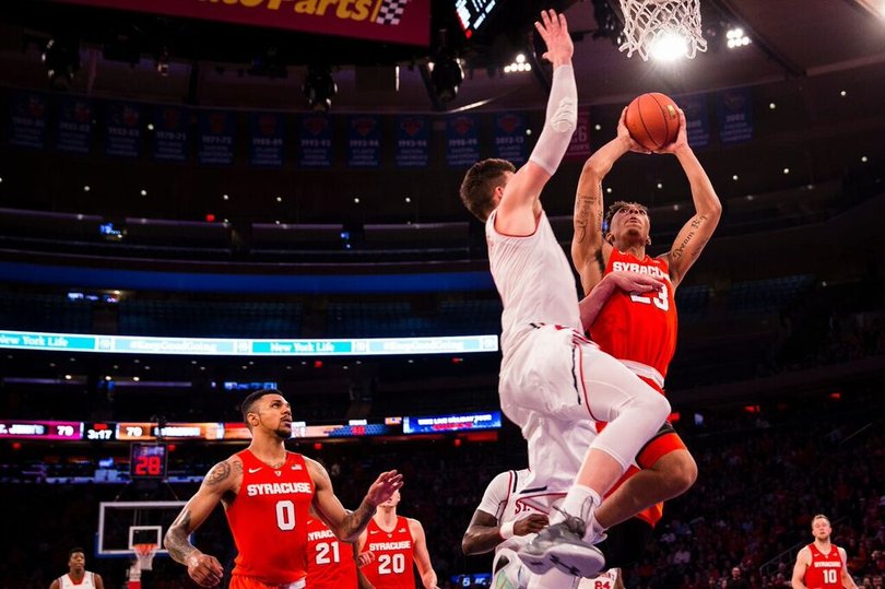 Richardson is guarded tightly as he goes toward the basket with two hands firmly gripped on the basketball.