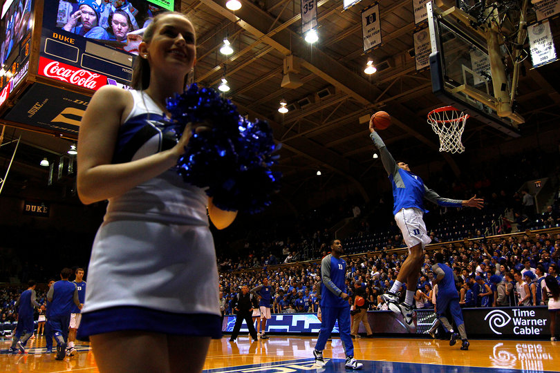 A Duke cheerleader stands along the baseline as Blue Devils warm up. Despite the raucous crowd support, Duke lost by two points.