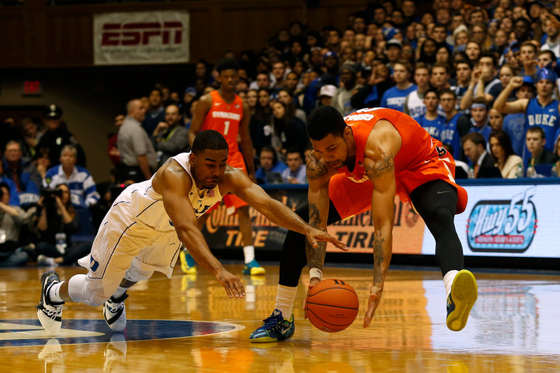 Gbinije battles for a loose ball on the floor. He scored 14 points and added nine assists for Syracuse. 