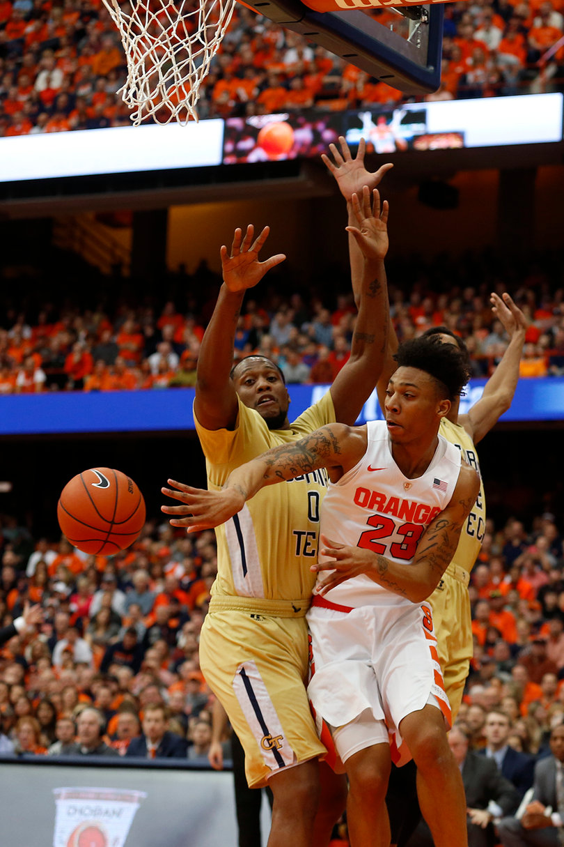 Richardson throws a pass out from under the basket as Georgia Tech forward Charles Mitchell pressures him. 