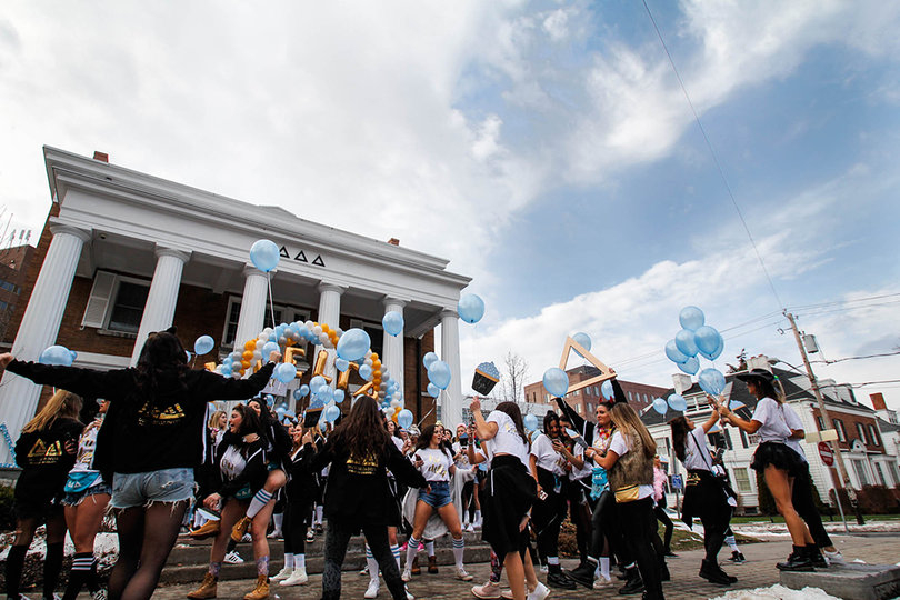 Delta Delta Delta sorority sisters gather outside of their house on Walnut Place with balloons and decorations to welcome new members.