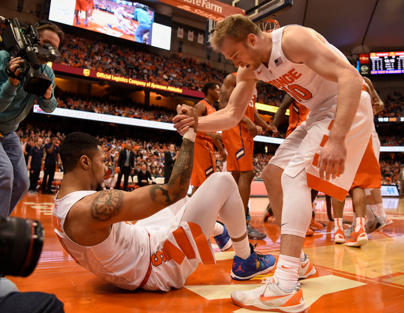 Syracuse guard Michael Gbinije is helped up by fellow guard Trevor Cooney. The duo combined for 34 points against the Tigers.