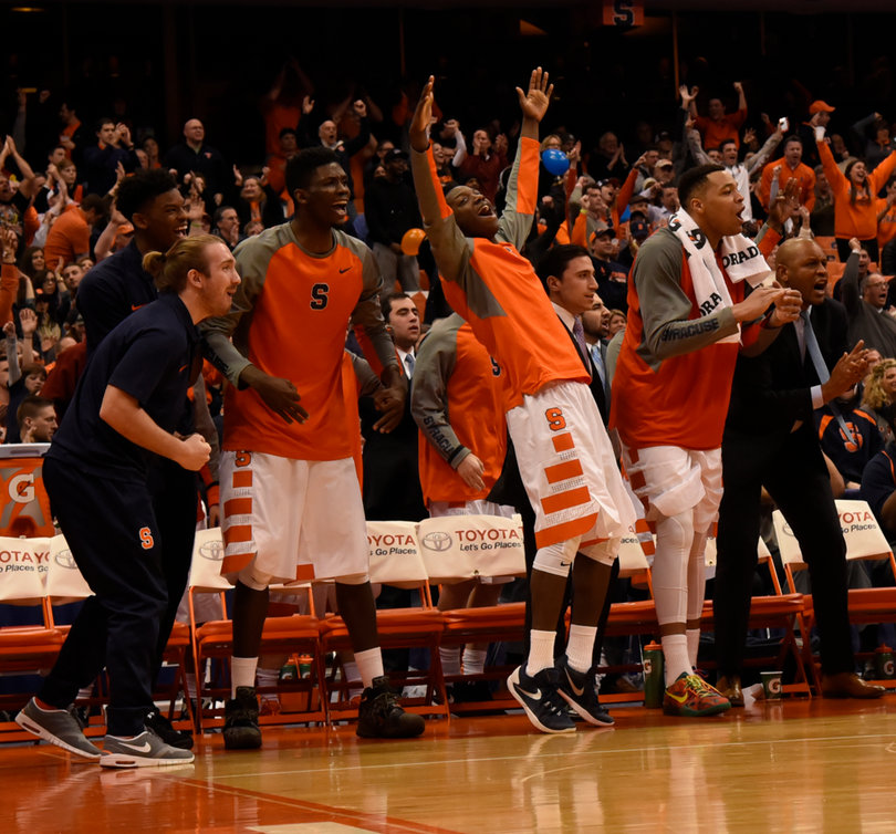 Players on Syracuse's bench stand and celebrate at one point during the game. Despite leading late in the game, the Orange blew the win in the second half and overtime.
