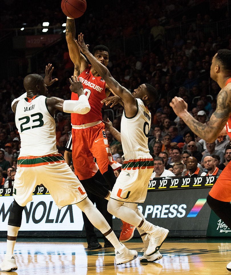 Gbinije dumps a pass to Coleman while Jekiri and guard Ja'Quan Newton converge on SU's point guard. 