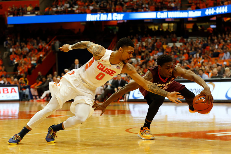 Michael Gbinije dives to steal the ball from a Virginia Tech guard in the first against the Hokies. 
