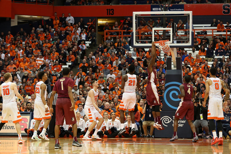 A Florida State player dunks the ball as Roberson, Lydon and Gbinije look on.