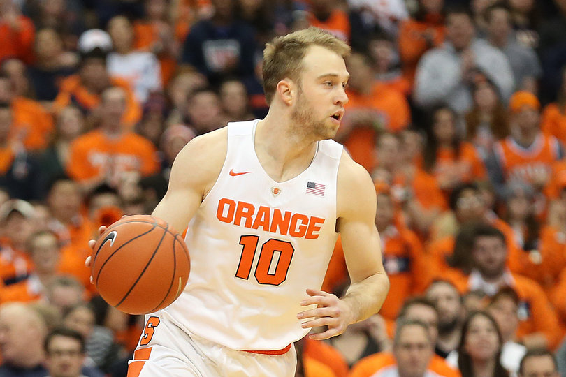 Cooney dribbles with the ball in his right hand while looking for options across the court.