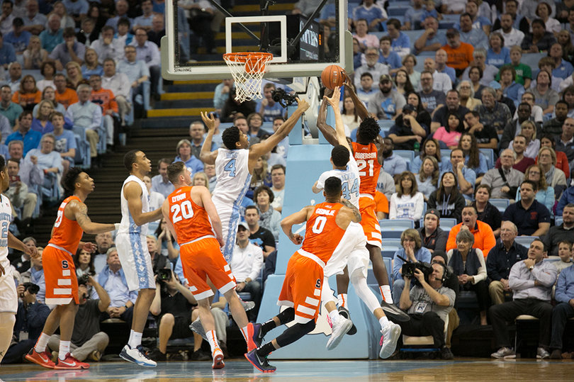 Players on both teams go for a rebound. 