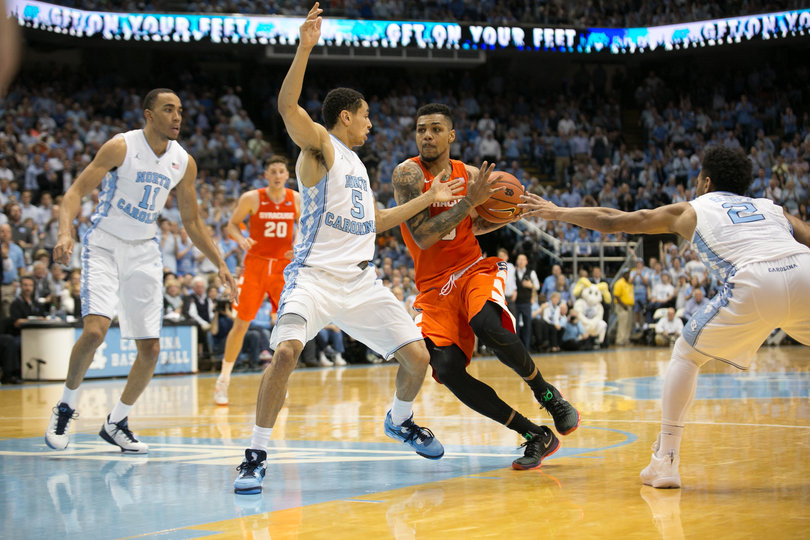 Gbinije drives into the lane against Joel Berry II and UNC point guard Marcus Paige. 