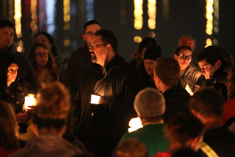 Community members listen to a prayer at the vigil. 