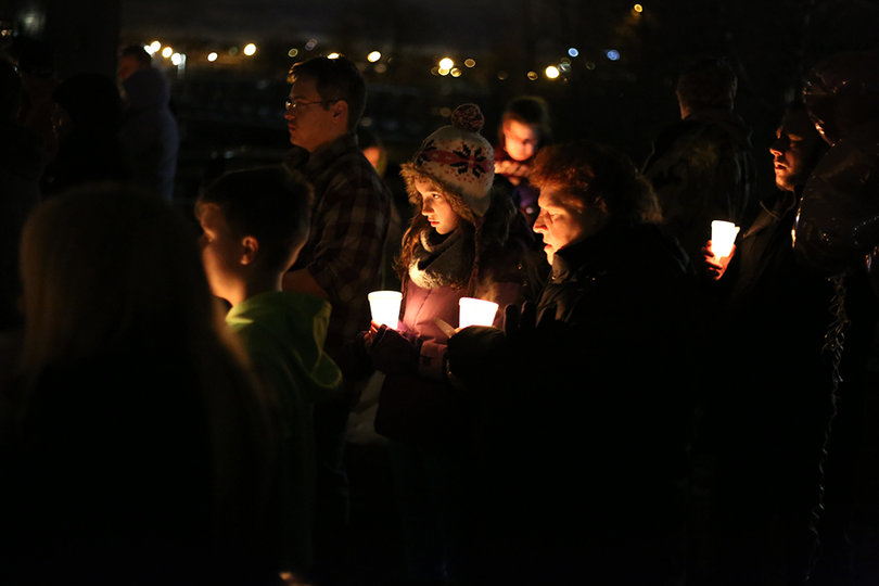 Attendees at Wednesday night's vigil look on.