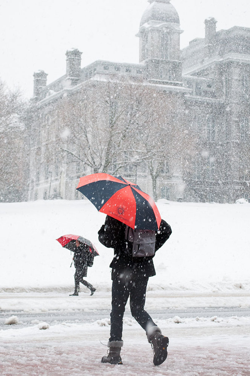 Snow falls as a student walks through Tuesday's snowy weather.