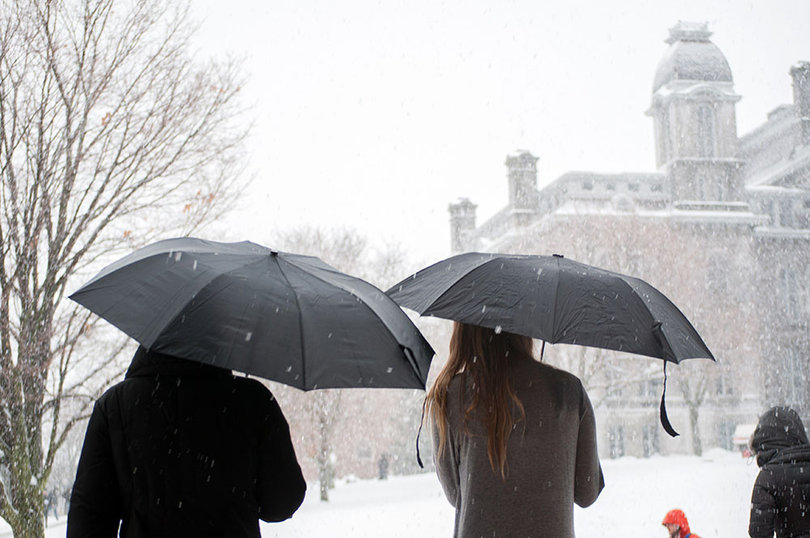 Two students hold umbrellas as they brave Tuesday's weather.