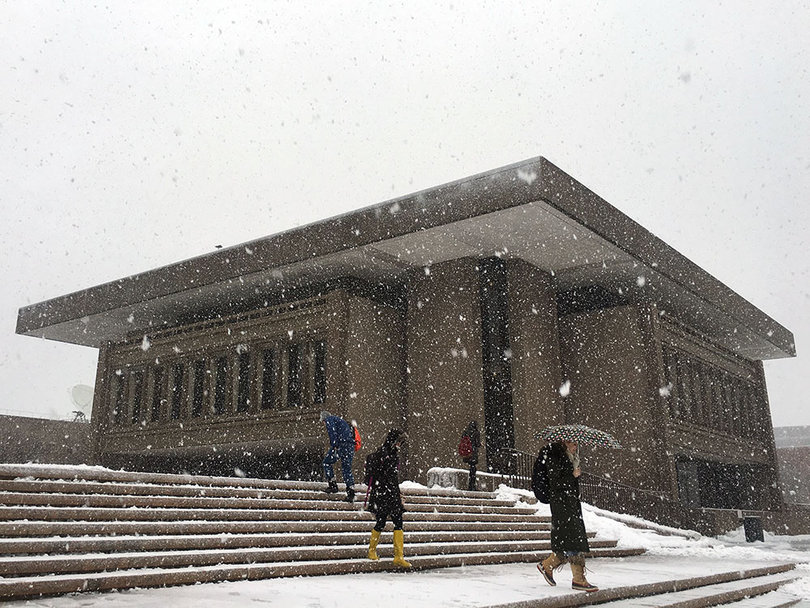 Multiple students walk down the steps at the S.I. Newhouse School of Public Communications.