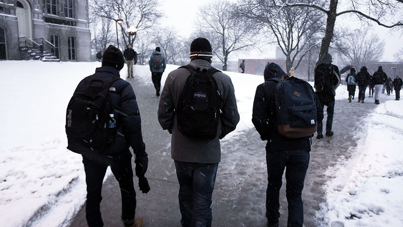 Students walk up a slushy sidewalk on SU's campus. 
