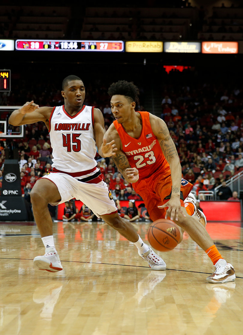Richardson puts the ball on the floor while Louisville's Mitchell defends him.