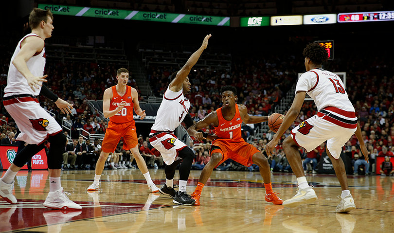 Frank Howard uses his body to protect the ball from Louisville defenders. The backup point guard scored one point against the Cardinals.