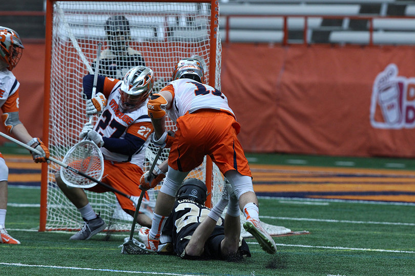 Syracuse goalie Warren Hill (27) defends a low shot taken by a diving Army attack. 