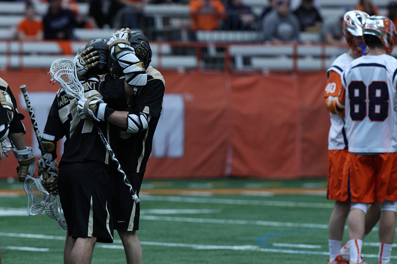 Two Army players celebrate a goal by the Black Knights as a group of Orange players stand by. 