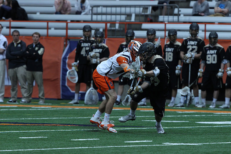 A Syracuse and Army player jostle for position in the middle of the field. 