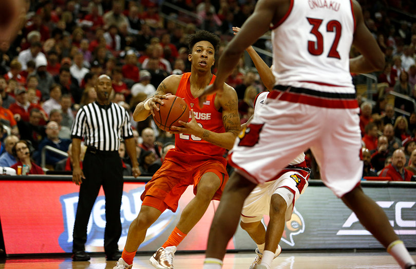 Richardson holds onto the ball as two Louisville defenders surround him.