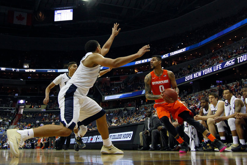 Gbinije holds the ball in the corner as a Pitt defender throws his left arm toward Gbinije's face.