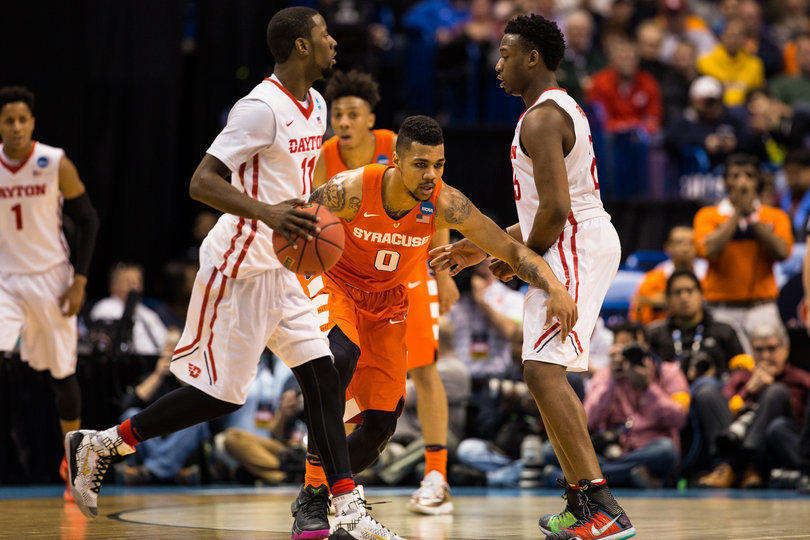 Syracuse point guard Michael Gbinije fights through a screen while trying to keep a Dayton player in front. 