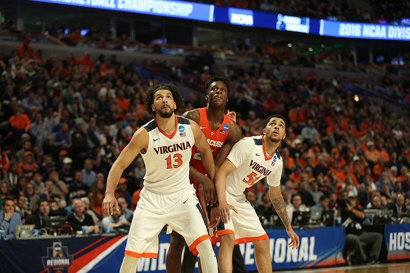 Two Virginia players box out Tyler Roberson during a free throw. Roberson finished with eight rebounds, four of which were offensive.