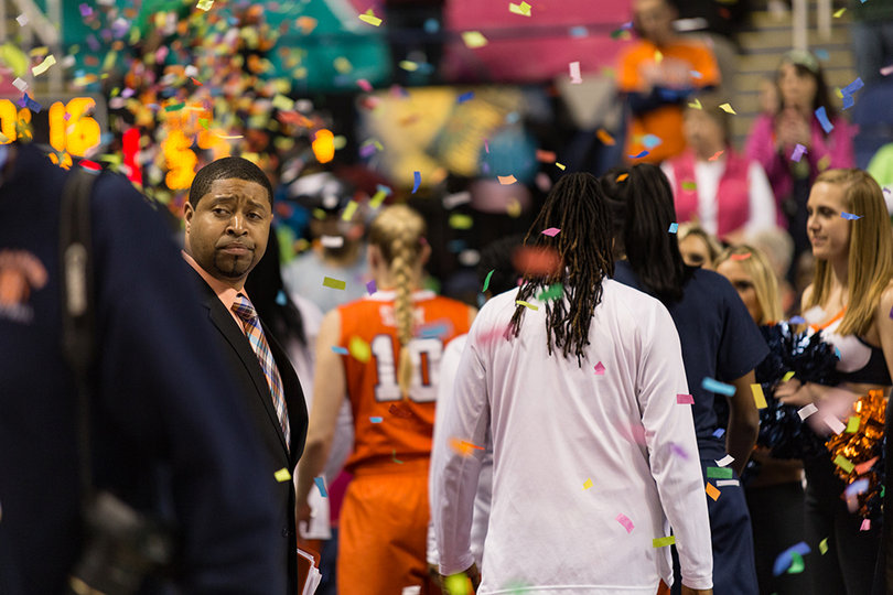 Syracuse assistant coach Cedric Solice looks back through the falling confetti to see Notre Dame celebrating the program's third-straight conference title.