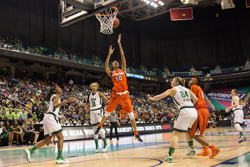 Briana Day leaps underneath the basket to corral a missed shot as three Notre Dame defenders look on.